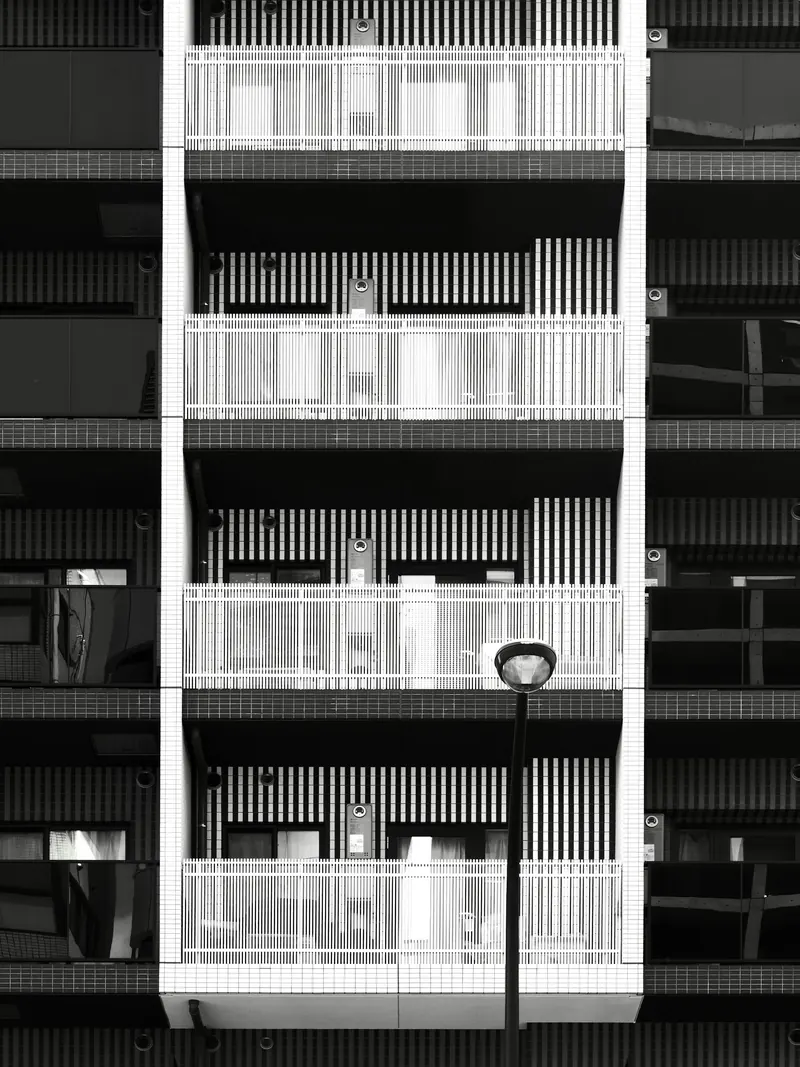 Façade d'immeuble résidentiel moderne avec balcons et lampadaire (photo d'illustration)