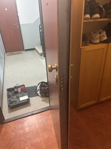 Porte d'entrée ouverte avec la caisse à outils du serrurier