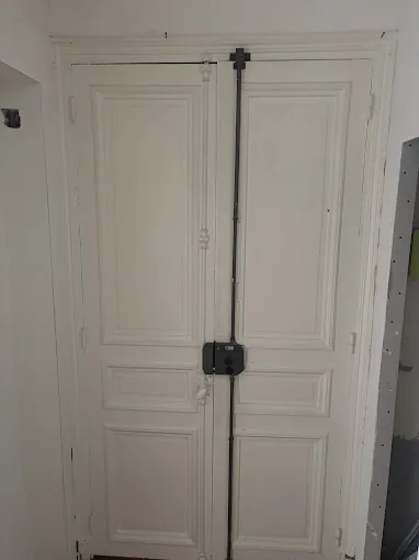 Porte ancienne à deux battants équipée d'une serrure trois points en applique